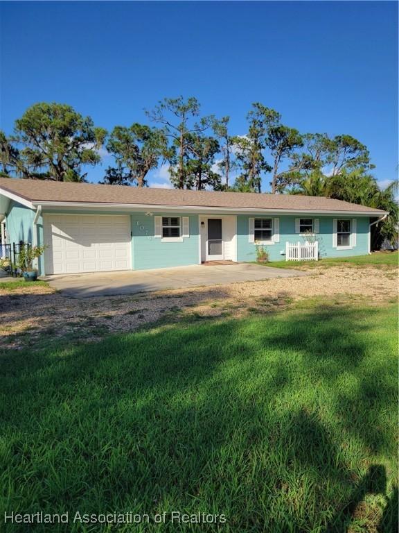 ranch-style house with a front yard and a garage