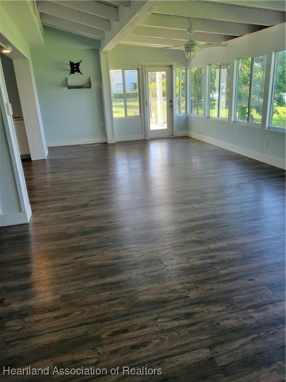 unfurnished sunroom with vaulted ceiling with beams and ceiling fan