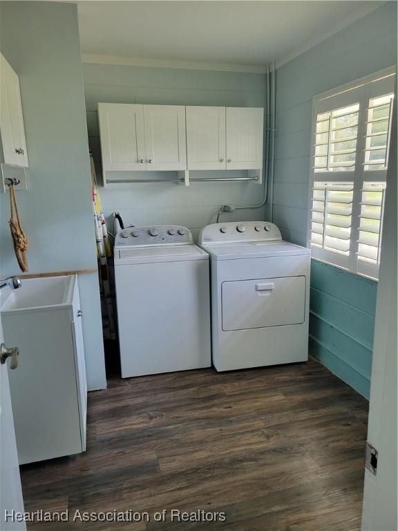 laundry area featuring cabinets, separate washer and dryer, dark wood-type flooring, and sink