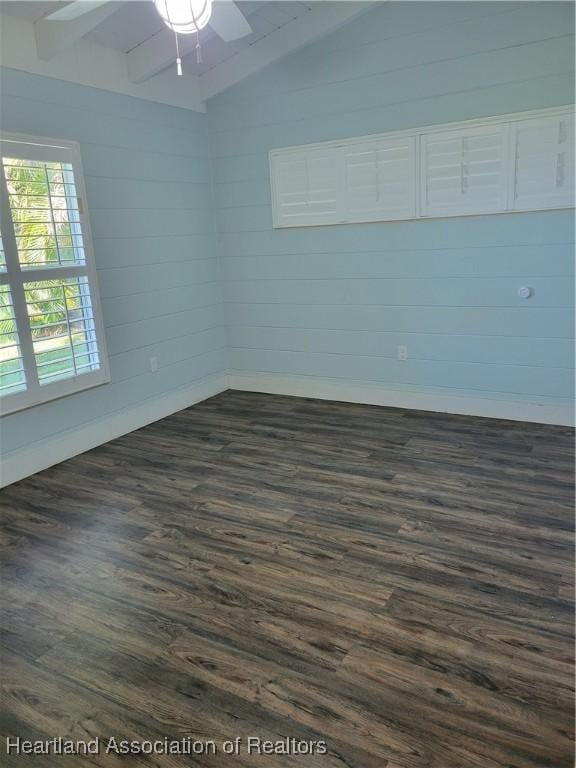 spare room featuring lofted ceiling, ceiling fan, and dark wood-type flooring