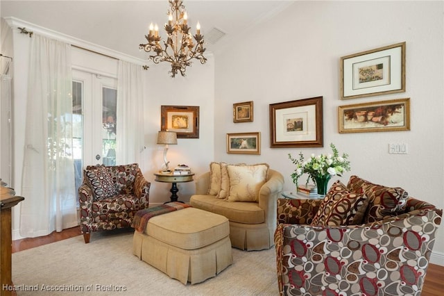 sitting room featuring ornamental molding, a chandelier, and light hardwood / wood-style flooring