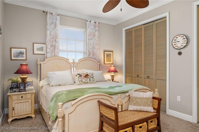 carpeted bedroom with ceiling fan, ornamental molding, and a closet