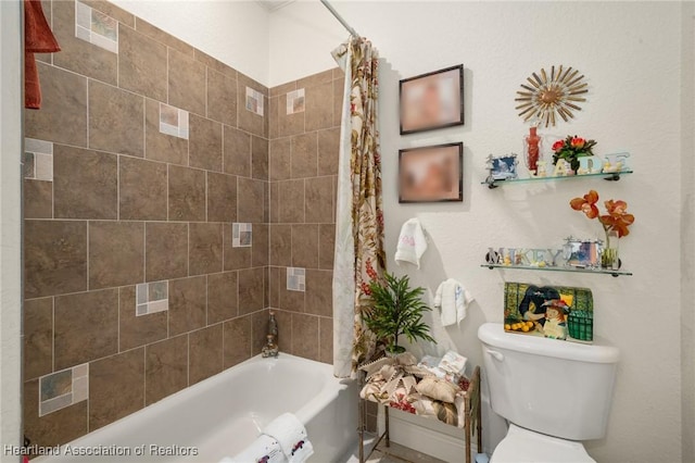 bathroom featuring shower / bathtub combination with curtain and toilet