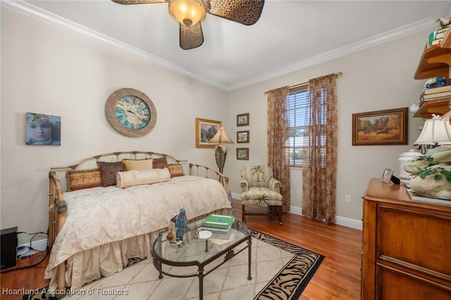 bedroom with ornamental molding, ceiling fan, and light hardwood / wood-style floors