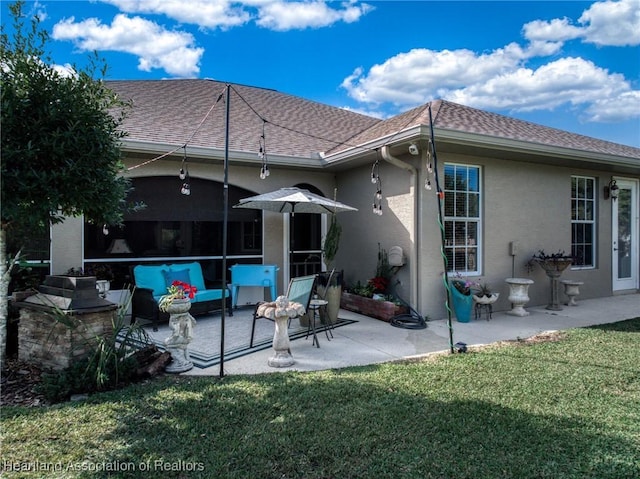 rear view of property with a patio and a lawn