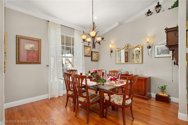 dining room with a notable chandelier, crown molding, and light hardwood / wood-style flooring