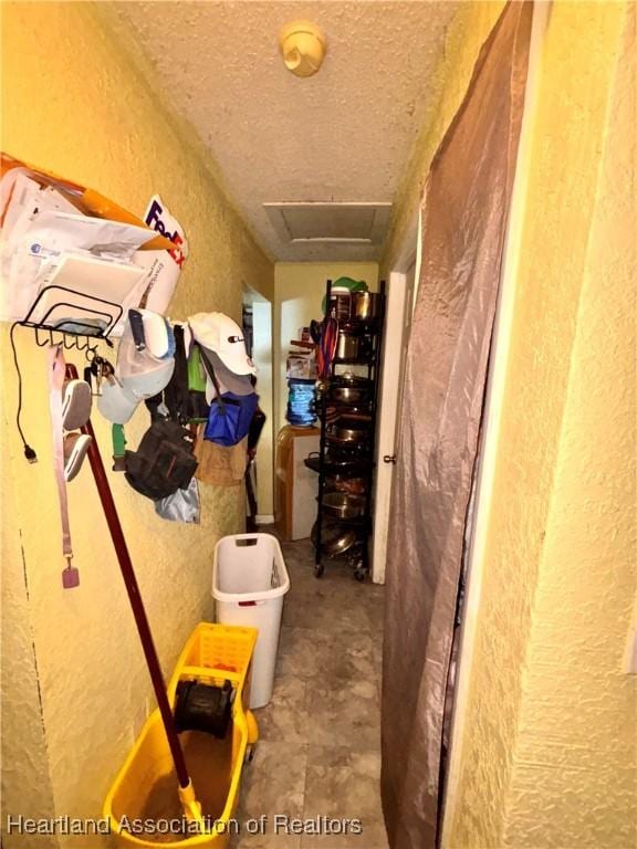 205 E Townsend St, Wauchula, FL 33873 - hallway with a textured wall, a textured ceiling, and attic access
