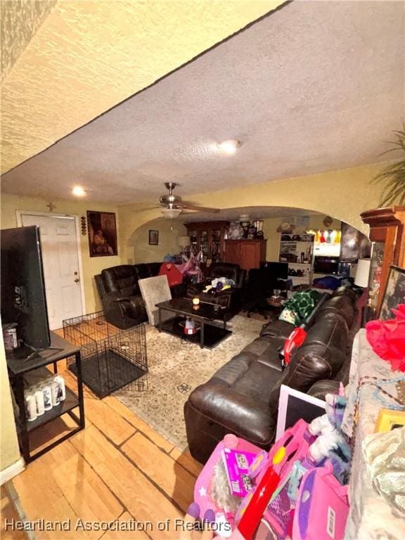 205 E Townsend St, Wauchula, FL 33873 - living room with a ceiling fan, wood finished floors, a textured ceiling, and arched walkways