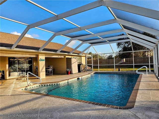 view of swimming pool with a patio and a lanai