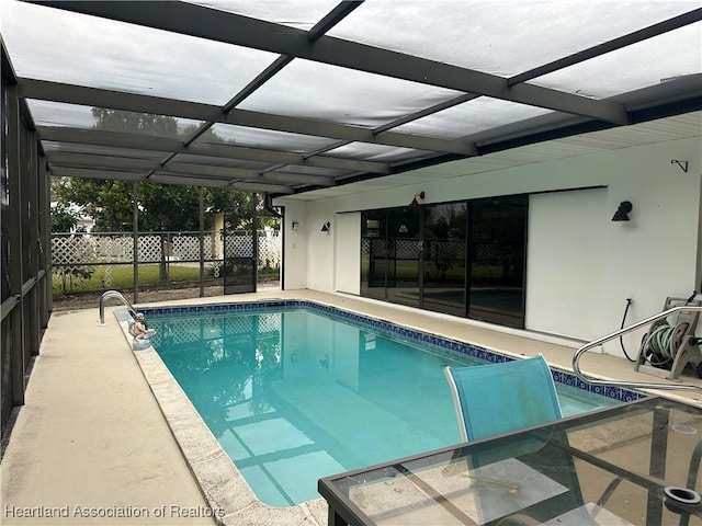 view of pool with a patio and glass enclosure