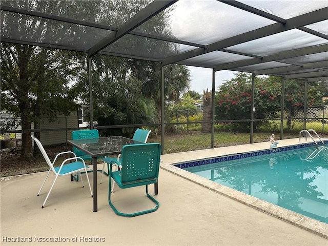 view of swimming pool with a patio area and glass enclosure