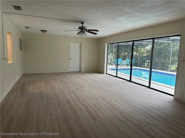 spare room with ceiling fan and light wood-type flooring