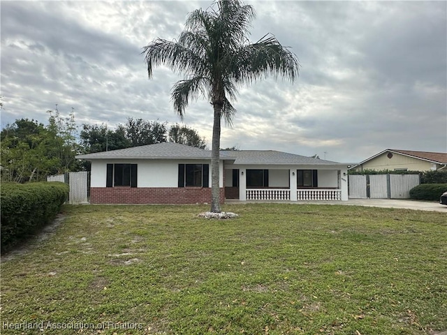 single story home with covered porch and a front yard