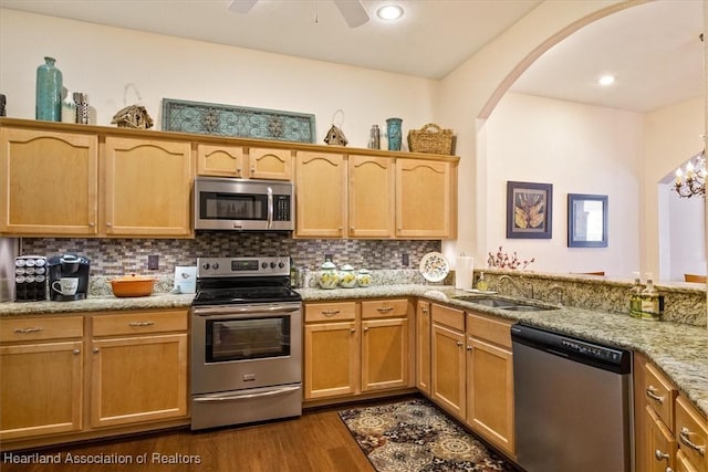 5220 Haw Rd, Sebring, FL 33875 - kitchen with stainless steel appliances, dark wood-style flooring, decorative backsplash, arched walkways, and recessed lighting
