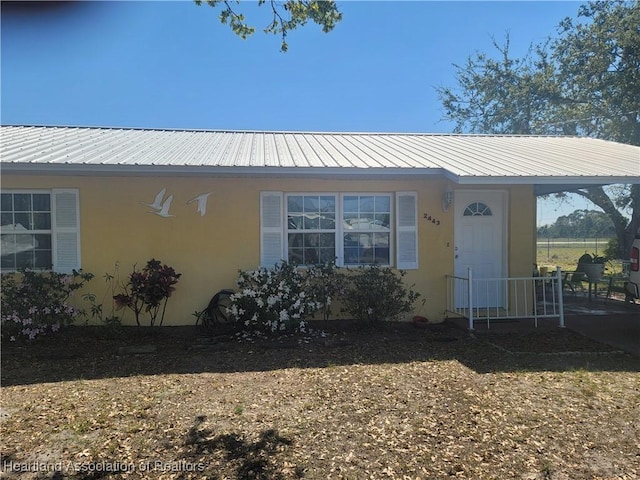 exterior space with metal roof and stucco siding