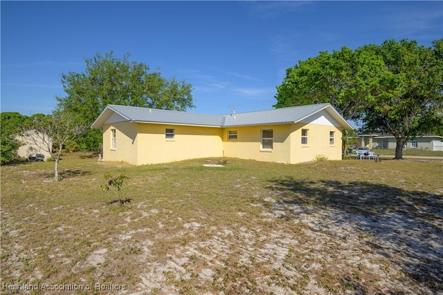 2443 W Newton Rd, Avon Park, FL 33825 - back of property featuring stucco siding, a yard, and metal roof