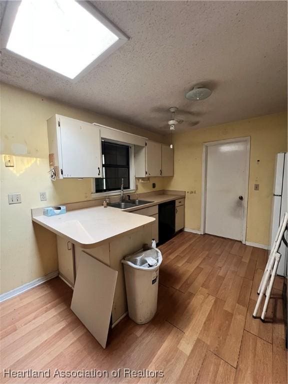 1801 Colmar Ave, Sebring, FL 33870 - kitchen featuring a sink, a peninsula, light wood-style floors, light countertops, and a textured ceiling