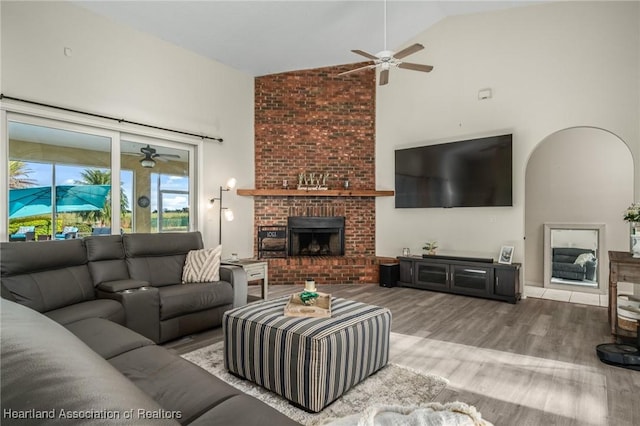 living room featuring a fireplace, hardwood / wood-style floors, and high vaulted ceiling