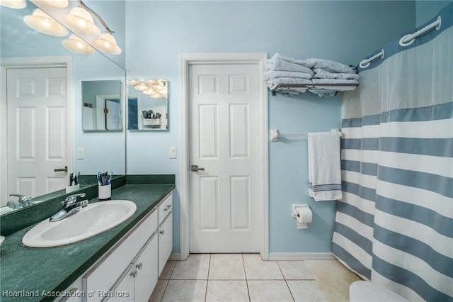 bathroom featuring tile patterned floors, vanity, and curtained shower