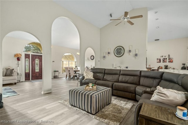 living room featuring ceiling fan, light hardwood / wood-style flooring, and high vaulted ceiling