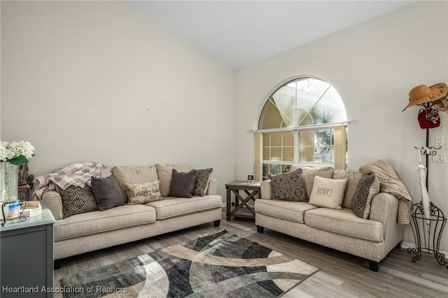 living room with vaulted ceiling and hardwood / wood-style flooring