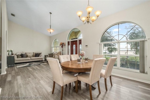 dining space featuring hardwood / wood-style floors and an inviting chandelier