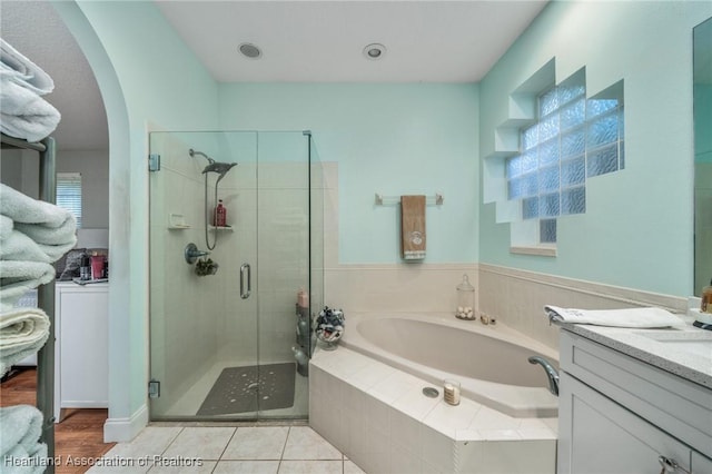 bathroom featuring tile patterned flooring, shower with separate bathtub, and vanity