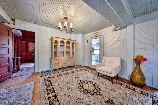sitting room with wood finished floors and an inviting chandelier