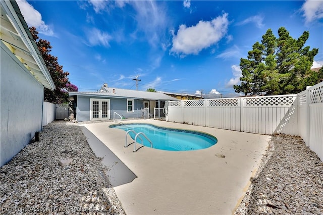 view of swimming pool featuring a fenced backyard, a patio, a fenced in pool, and french doors