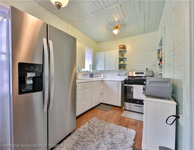 kitchen featuring light wood-style flooring, white cabinetry, open shelves, light countertops, and appliances with stainless steel finishes