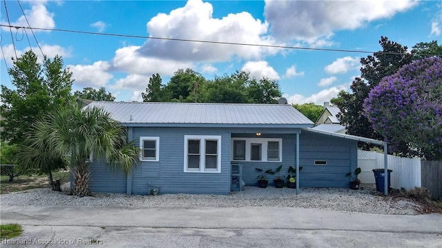 exterior space with fence and metal roof