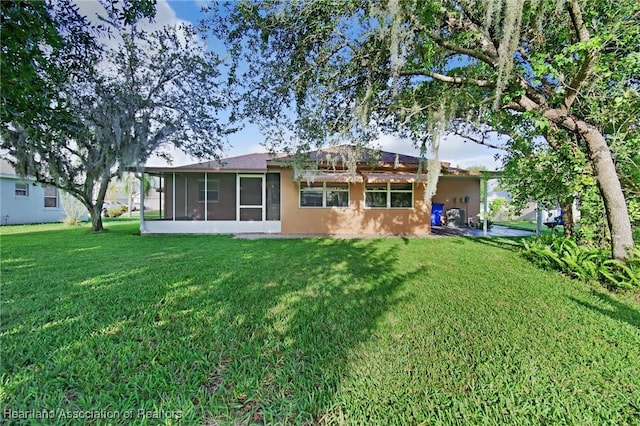 4311 Mandarin Rd, Sebring, FL 33875 - rear view of house with a sunroom, a lawn, and stucco siding