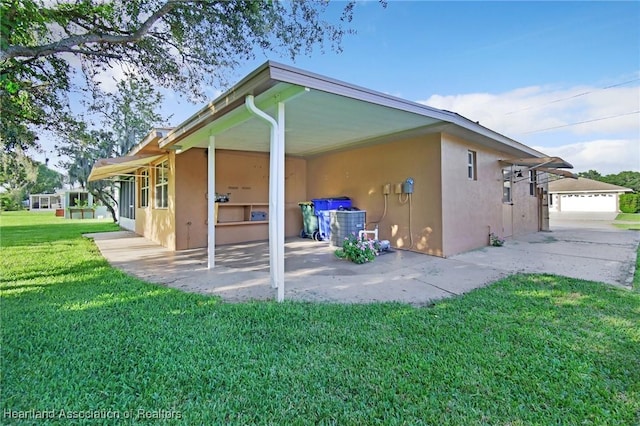 4311 Mandarin Rd, Sebring, FL 33875 - back of property featuring stucco siding, a yard, and an attached carport