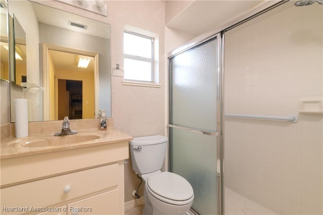 bathroom featuring vanity, toilet, and a shower with door