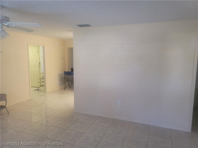 tiled spare room featuring ceiling fan