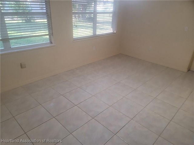 spare room featuring light tile patterned floors and a wealth of natural light