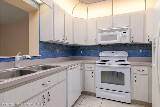 kitchen featuring light tile patterned flooring, sink, white appliances, and decorative backsplash