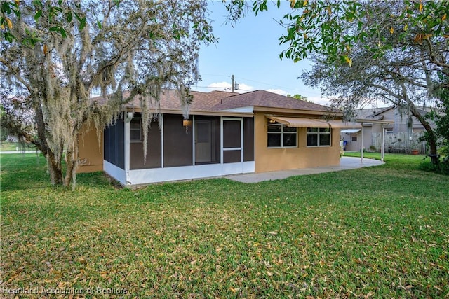 rear view of property with a patio, a sunroom, and a yard