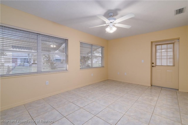 tiled spare room with ceiling fan