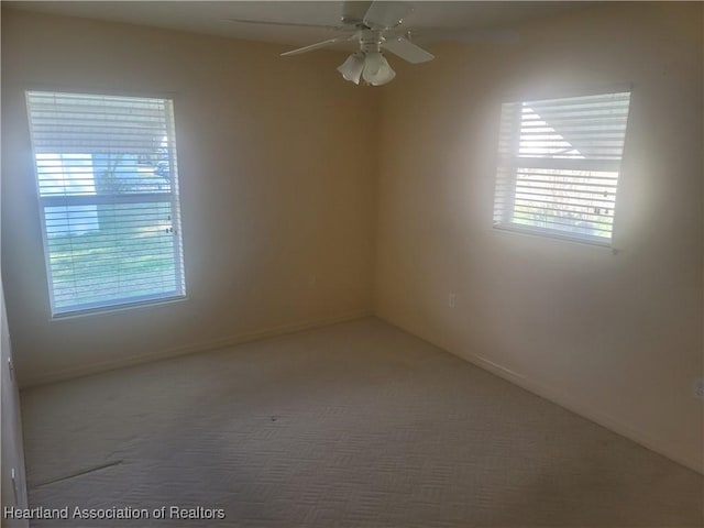 spare room featuring a healthy amount of sunlight, ceiling fan, and carpet flooring