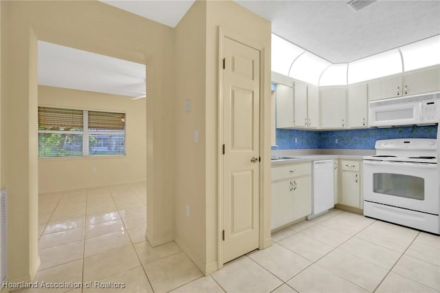 4311 Mandarin Rd, Sebring, FL 33875 - kitchen featuring white appliances, light tile patterned floors, light countertops, decorative backsplash, and white cabinetry
