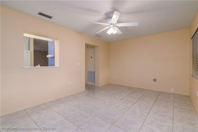 tiled empty room with ceiling fan