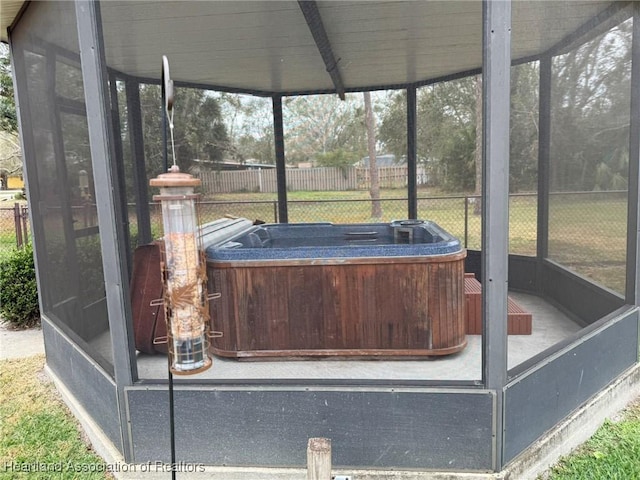 unfurnished sunroom with a hot tub