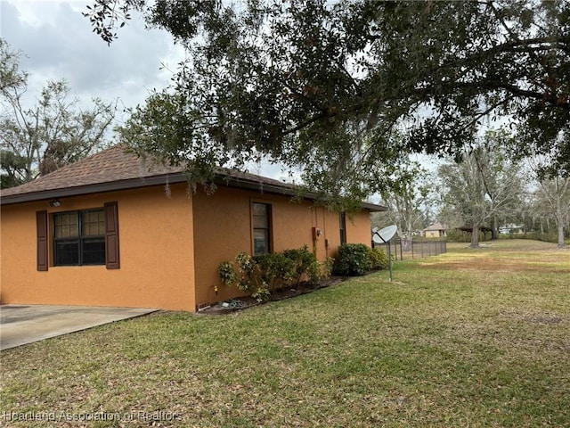 view of side of property with a yard and a patio area