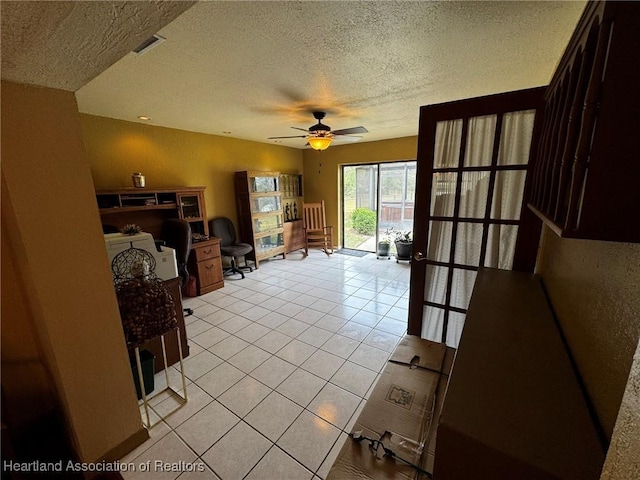 tiled living room featuring ceiling fan and a textured ceiling