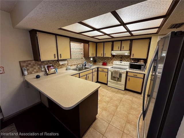 kitchen with white electric range, sink, decorative backsplash, kitchen peninsula, and black fridge