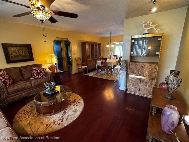 living room with ceiling fan, dark hardwood / wood-style floors, and a textured ceiling