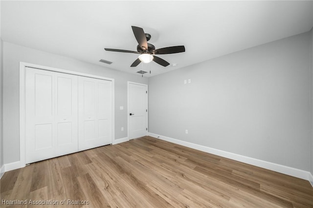 unfurnished bedroom featuring ceiling fan, light wood-type flooring, and a closet