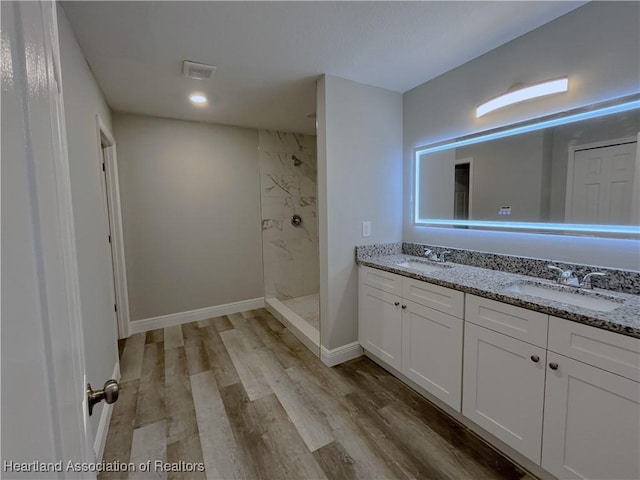 bathroom with wood-type flooring, vanity, and walk in shower