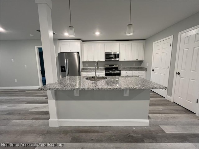 kitchen with white cabinetry, sink, stainless steel appliances, and stone countertops